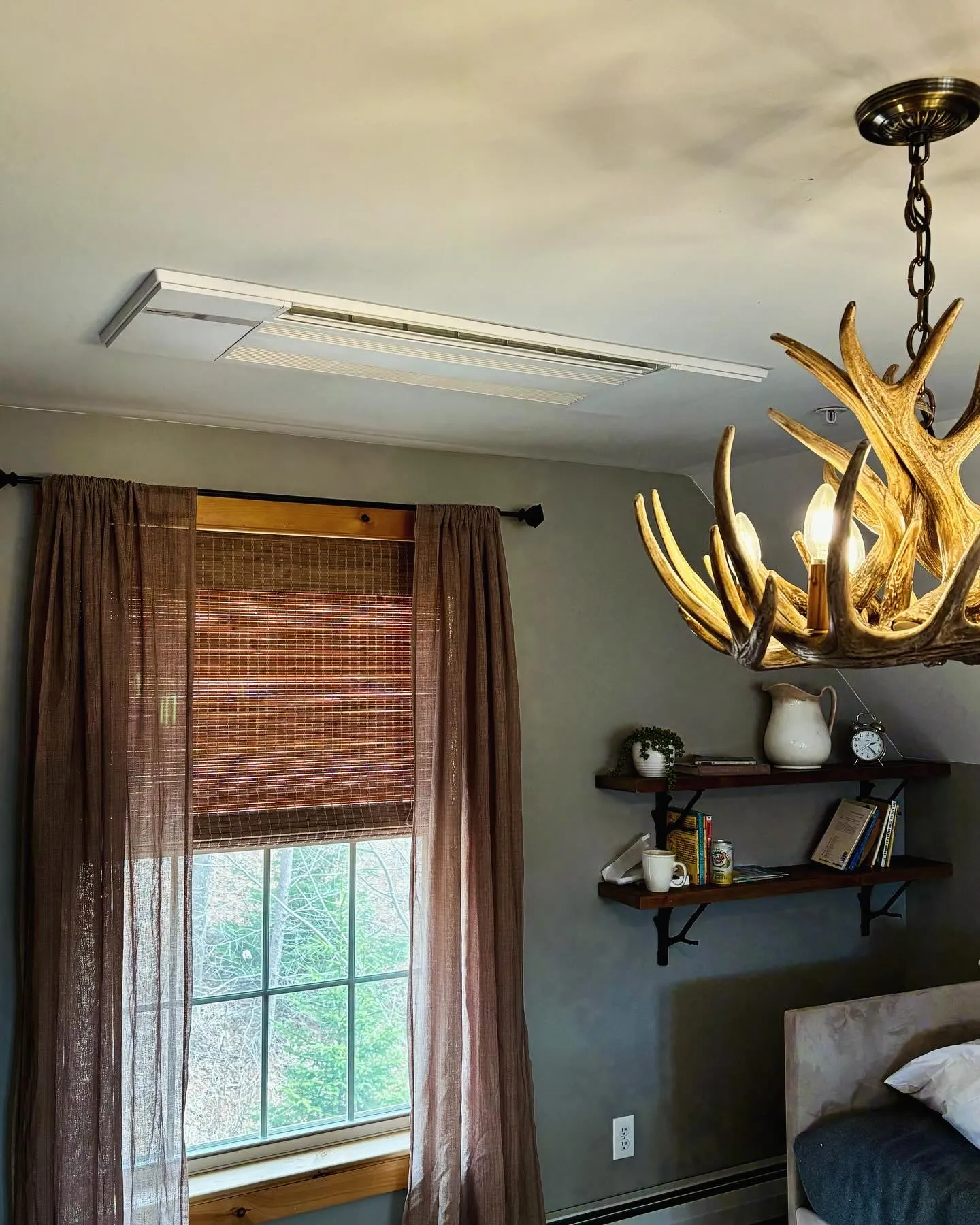 Ceiling-mounted ductless mini-split cassette installed in a Southern Maine bedroom