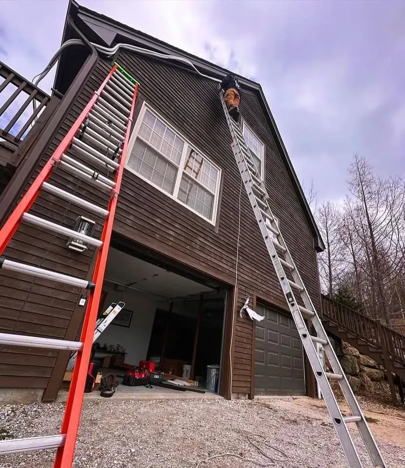 Southern Maine Mechanical ladders set against a Maine home for an exterior HVAC installation