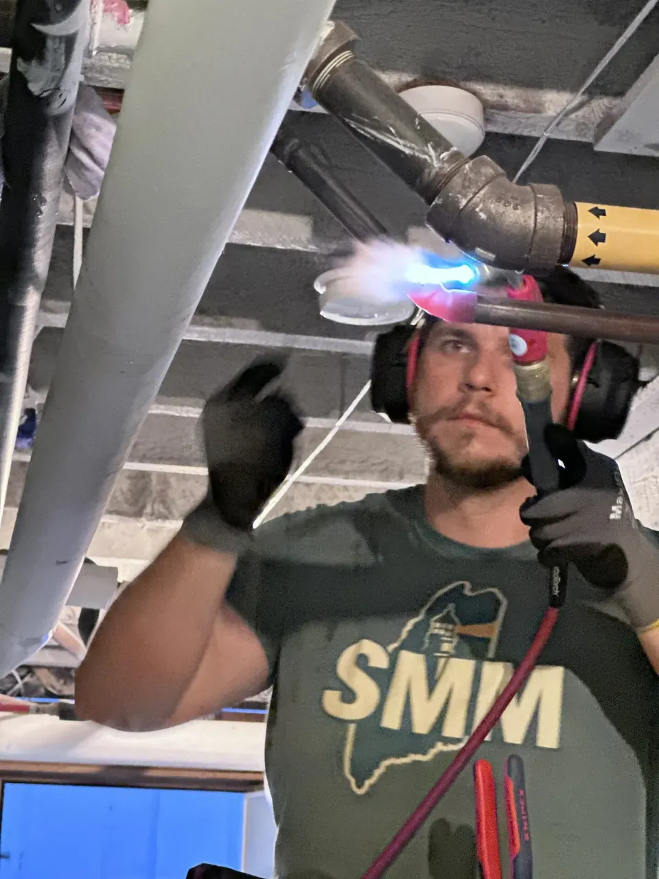 Southern Maine Mechanical technician soldering a copper line with a torch during an HVAC installation